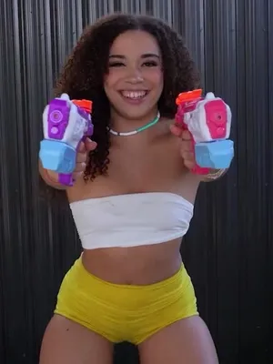 Bitch in yellow shorts, seductively gripping dual cocks of squirty pleasure.